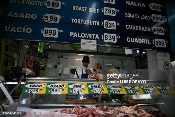 Worker attends a butcher shop in Buenos Aires on January 12, 2023. - Argentina registered inflation of 94.8 percent in 2022, its highest annual...