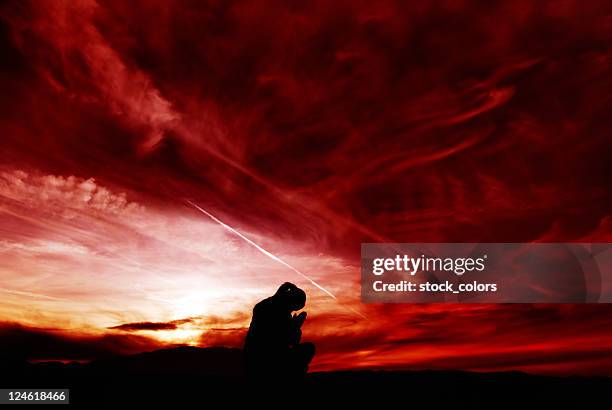 praying - good evil stock pictures, royalty-free photos & images