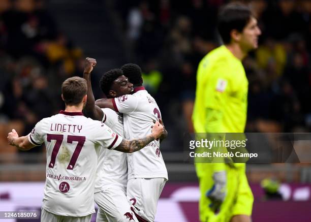 Michel Adopo of Torino FC celebrates with Brian Bayeye and Karol Linetty of Torino FC after scoring a goal as Ciprian Tatarusanu of AC Milan looks...