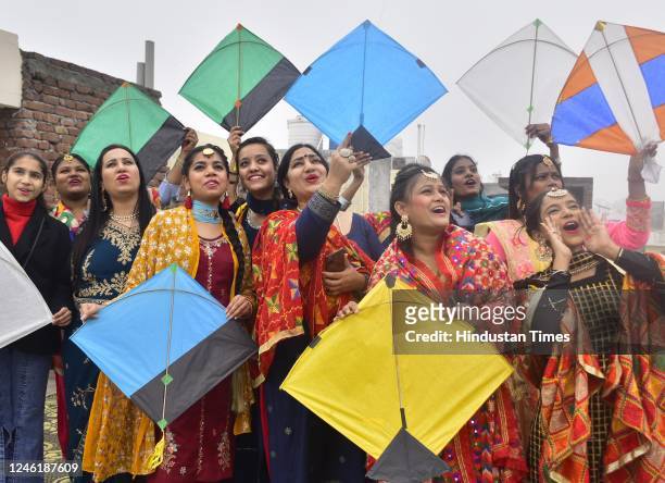 Students with staff members fly kites during celebration on the eve of the Lohri on January 12, 2023 in Amritsar, India.