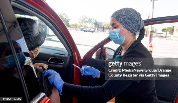 Amirah Chalabi, LVN administers a Pfizer-BioNTech COVID-19 shot at the drive through vaccination site at Santa Ana College in Santa Ana, CA on...