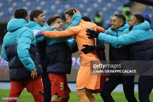 Barcelona's German goalkeeper Marc-Andre ter Stegen is congratulated by teammates after winning the Spanish Super Cup semi-final football match...