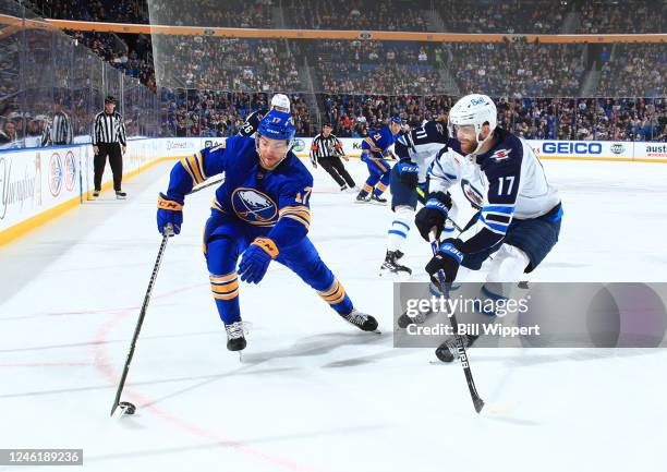 Adam Lowry of the Winnipeg Jets defends against Tyson Jost of the Buffalo Sabres during an NHL game on January 12, 2023 at KeyBank Center in Buffalo,...