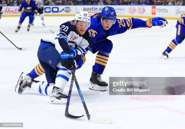 Karson Kuhlman of the Winnipeg Jets controls the puck against Owen Power of the Buffalo Sabres during an NHL game on January 12, 2023 at KeyBank...