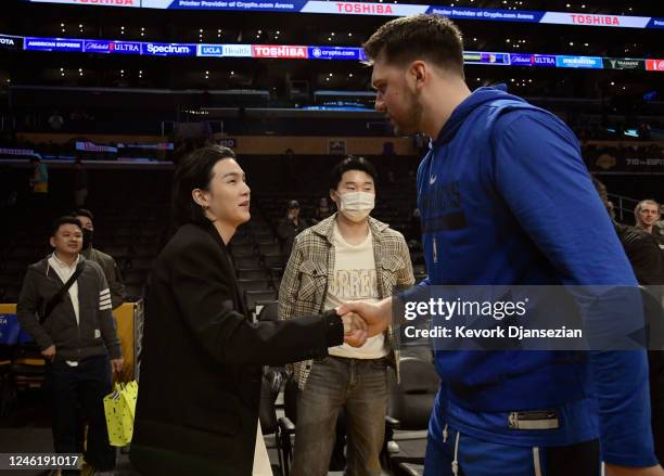 Luka Doncic of the Dallas Mavericks greets Suga, a member of the South Korean band BTS, before the game between the Los Angeles Lakers and Dallas...