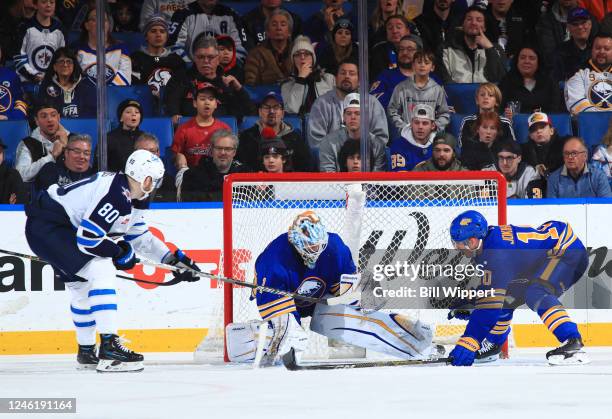 Ukko-Pekka Luukkonen and Henri Jokiharju of the Buffalo Sabres defend the net against Pierre-Luc Dubois of the Winnipeg Jets during an NHL game on...