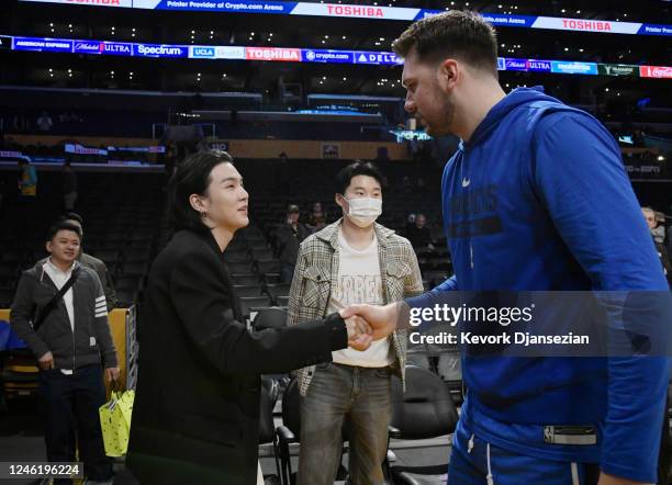 Luka Doncic of the Dallas Mavericks greets Suga, a member of the South Korean band BTS, before the game between the Los Angeles Lakers and Dallas...