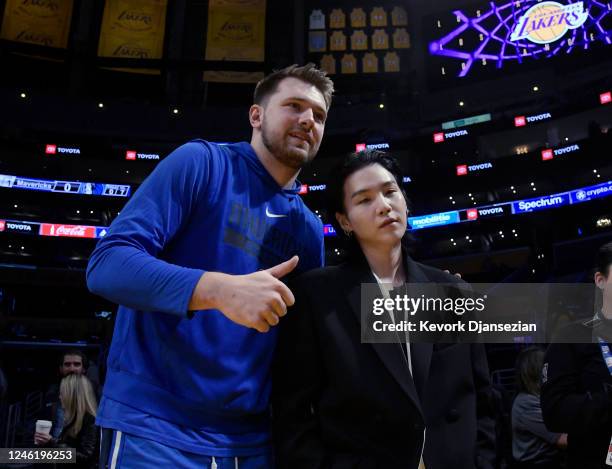 Luka Doncic of the Dallas Mavericks poses with Suga, a member of the South Korean band BTS, before the game between the Los Angeles Lakers and Dallas...