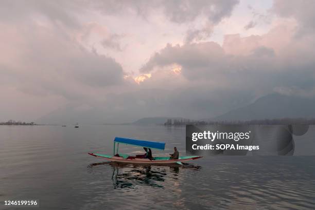 Boatman rows his Shikara boat on Dal Lake during a cloudy evening in Srinagar. Fresh snowfall in the higher reaches of the Kashmir valley and rains...