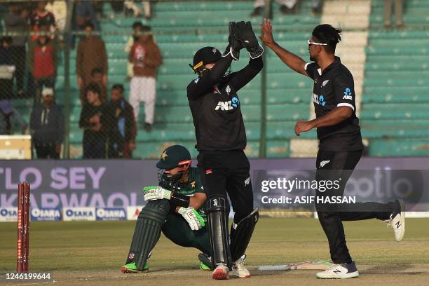 New Zealand's Ish Sodhi celebrates with teammate Tom Latham after taking the wicket of Pakistan's Mohammad Rizwan during the third and final one-day...