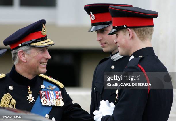 Britain's Prince Charles speaks with his two sons Prince's William and Harry after attending the Sovereign's Parade at the Royal Military Academy in...