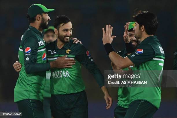 Pakistan's Agha Salman celebrates with teammates after taking the wicket of New Zealand's Daryl Mitchell during the third and final one-day...