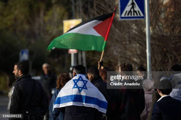 Jewish man unfurls Israeli flag during the demonstration of Palestinian people who protest against the illegal Jewish settlements and deportation...