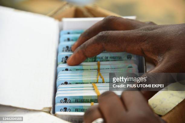 An official of the Independent National Electoral Commission sort out Permanent Voters cards of voters at a ward in Lagos on January 12, 2023 ahead...