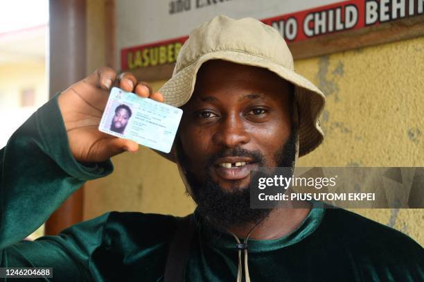 Man shows his Permanent Voters Card collected from Officials of the Independent National Electoral Commission at a ward in Lagos on January 12, 2023...