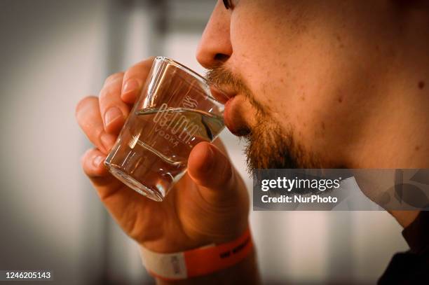 Man drinks vodka from a small shot glass at the Vodka Museum in Warsaw, Poland on 13 January, 2022.