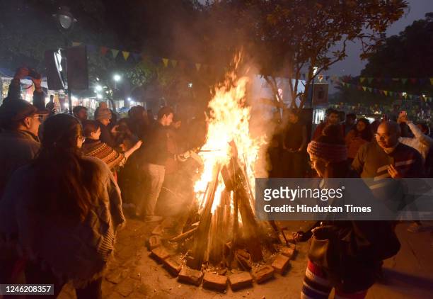 People burning born fire enjoying and celebrating Lohri festival at Delhi Haat INA in New Delhi India on Friday, January 13, 2023. Lohri is a popular...