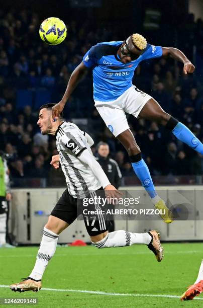 Napoli's Nigerian forward Victor Osimhen heads the ball to score a goal in front of Napoli's Uruguayan defender Mathias Olivera during the Italian...