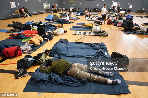Migrant lie on the sleeping pad at a makeshift shelter in Denver, Colorado on Friday, January 13, 2023.