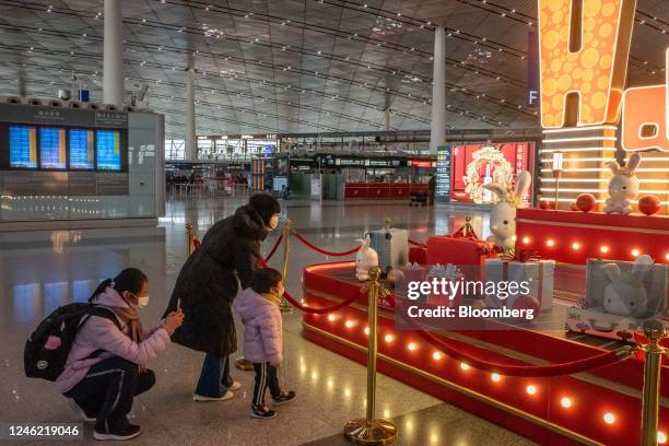 Travelers next to an installation for Lunar New Year at Beijing Capital International Airport in Beijing, China, on Saturday, Jan. 14, 2023. There...