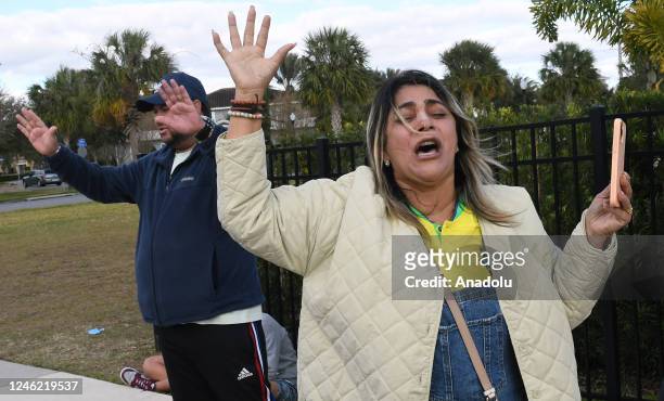Supporters of former Brazilian far-right President Jair Bolsonaro pray for him outside the home he is staying in at Encore resort at Reunion on...