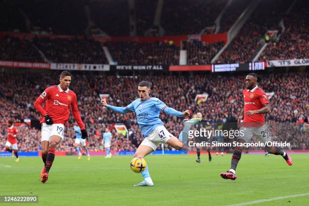 Phil Foden of Manchester City battles with Raphael Varane of Manchester United and Aaron Wan-Bissaka of Manchester United during the Premier League...
