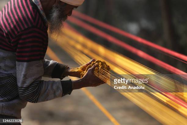 An Indian worker prepares kite thread at a roadside workshop, in Amritsar, India on January 04, 2023. The kite thread called, 'Dor', in the local...