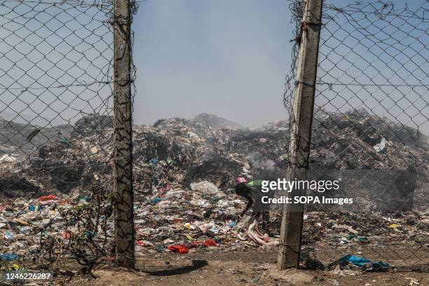 Young waste picker recovers waste for recycling amidst heavy smoke from burning garbage at the Nakuru main dumping yard. Since waste is rarely...