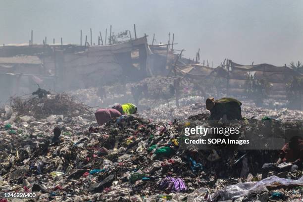 Waste pickers recover waste for recycling amidst heavy smoke from burning garbage at the Nakuru main dumping yard. Since waste is rarely segregated...