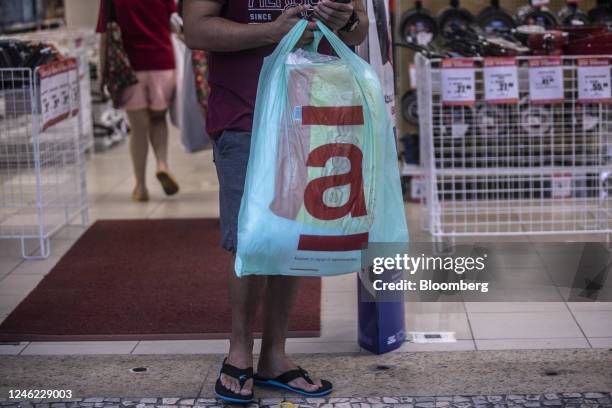 Customers carries an Americanas shopping bag while exiting a store in Rio de Janeiro, Brazil, on Friday, Jan. 13, 2023. Lenders to Americanas SA are...