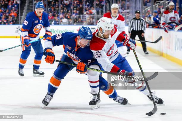 Brock Nelson of the New York Islanders and Joel Armia of the Montreal Canadiens battle for the puck during the second period at UBS Arena on January...