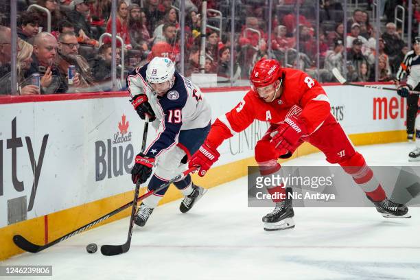 Liam Foudy of the Columbus Blue Jackets and Ben Chiarot of the Detroit Red Wings fight for possession of the puck during the third period of the game...
