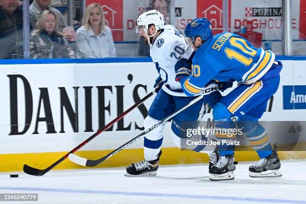 Brayden Schenn of the St. Louis Blues battles Nicholas Paul of the Tampa Bay Lightning for the puck at the Enterprise Center on January 14, 2023 in...