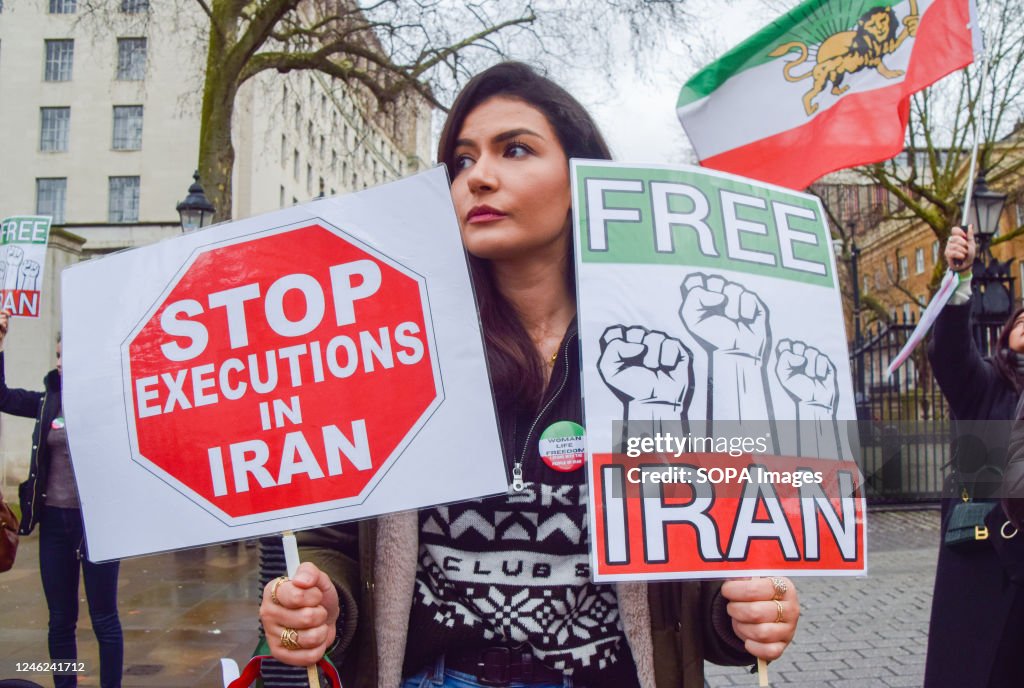 A protester holds 'Stop executions in Iran' and 'Free Iran'...