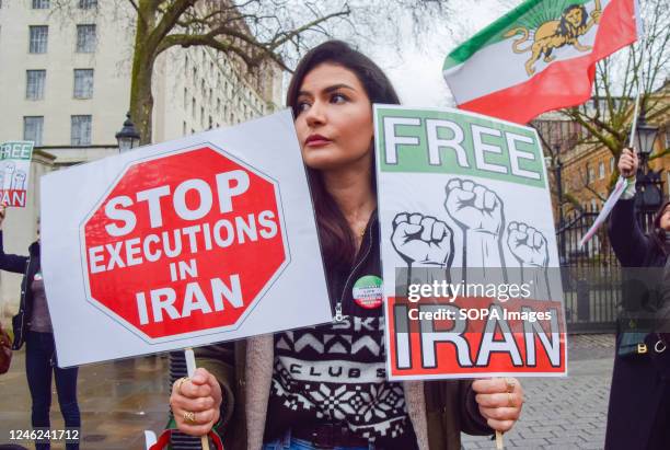 Protester holds 'Stop executions in Iran' and 'Free Iran' placards during the demonstration. Demonstrators gathered outside Downing Street in protest...