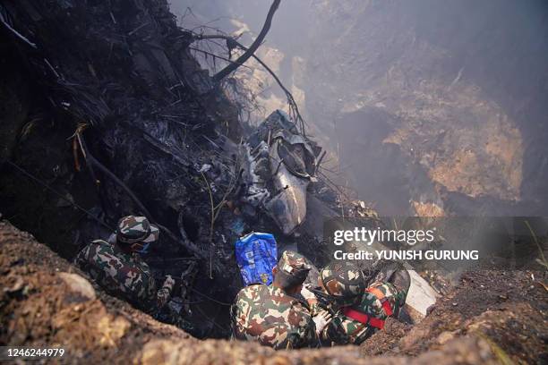 Rescuers inspect the site of a Yeti Airlines plane crash in Pokhara on January 15, 2023. - An aircraft with 72 people on board crashed in Nepal on...