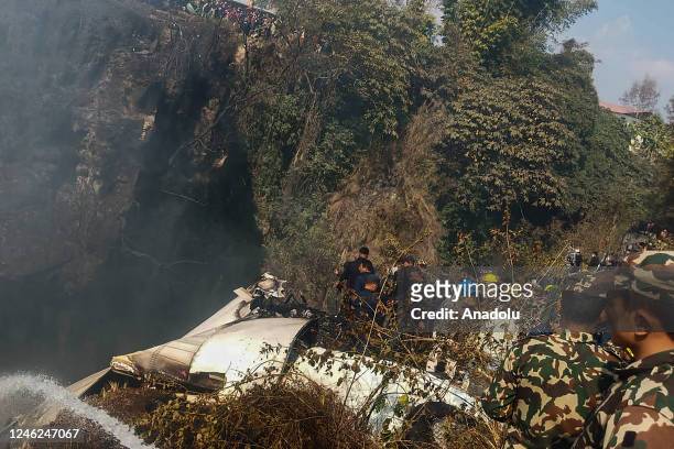 Rescuers gather at the site of a plane crash in Pokhara, Nepal on January 15, 2023. Yeti Airlines plane carrying more than 70 people crashed.