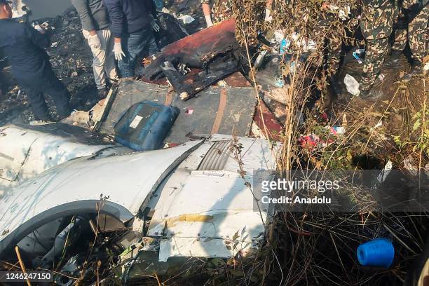 Rescuers gather at the site of a plane crash in Pokhara, Nepal on January 15, 2023. Yeti Airlines plane carrying more than 70 people crashed.