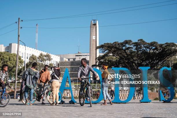 Youngsters socialize in front of a sign in a square in the city of Addis Ababa, Ethiopia, on January 15, 2023. Portions of downtown Addis Ababa is...