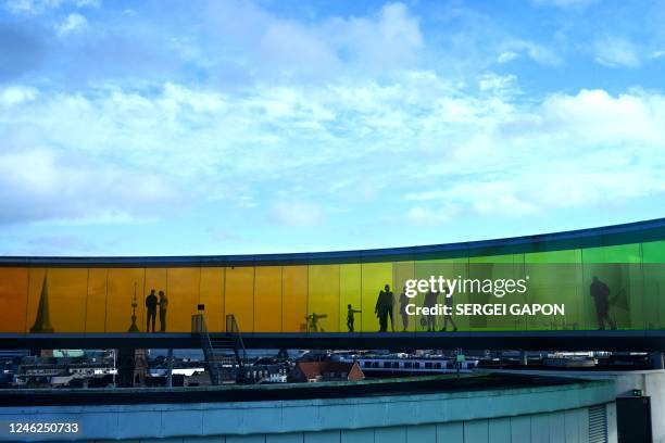 People visit 'Your rainbow panorama' by Danish-Icelandic artist Olafur Eliasson on top of the ARoS Art Museum in Aarhus, on January 15, 2023. - Your...