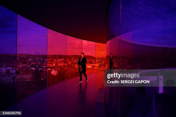 Man visits 'Your rainbow panorama' by Danish-Icelandic artist Olafur Eliasson on top of the ARoS Art Museum in Aarhus, on January 15, 2023. - Your...