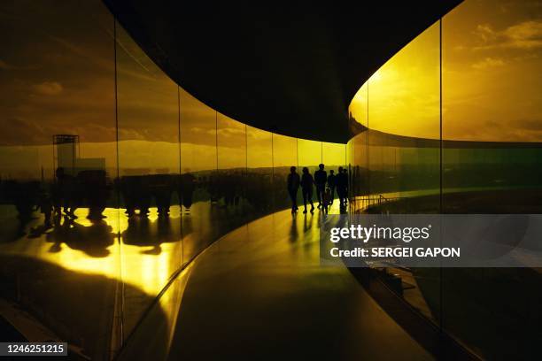 People visit 'Your rainbow panorama' by Danish-Icelandic artist Olafur Eliasson on top of the ARoS Art Museum in Aarhus, on January 15, 2023. - Your...
