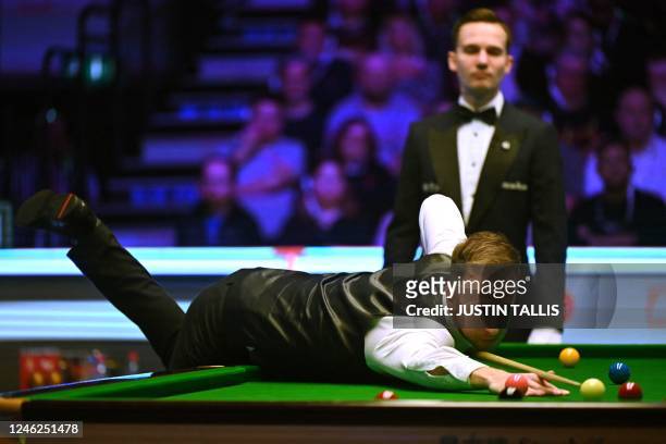 England's Judd Trump plays a shot during the Masters snooker tournament final against Wales' Mark Williams at Alexandra Palace in London on January...