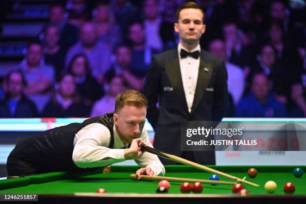 England's Judd Trump plays a shot during the Masters snooker tournament final against Wales' Mark Williams at Alexandra Palace in London on January...