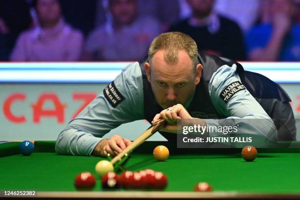 Wales' Mark Williams plays a shot during the Masters snooker tournament final against England's Judd Trump at Alexandra Palace in London on January...