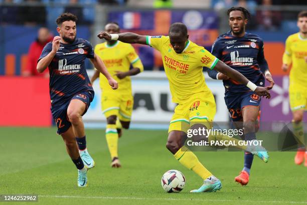 Montpellier's French midfielder Jordan Ferri and Montpellier's Cameroonian defender Enzo Tchato fight for the ball with Nantes' French midfielder...