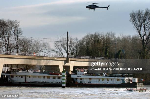 Un hélicoptère patrouille, le 19 janvier 2004 sur le Rhône à la hauteur de La Voulte, à la recherche d'un homme d'équipage qui a disparu dans le...