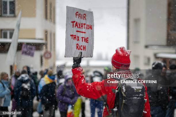 Young Socialists Switzerland activists take part in a protest against the World Economic Forum , calling for a climate tax on the rich, on the eve of...