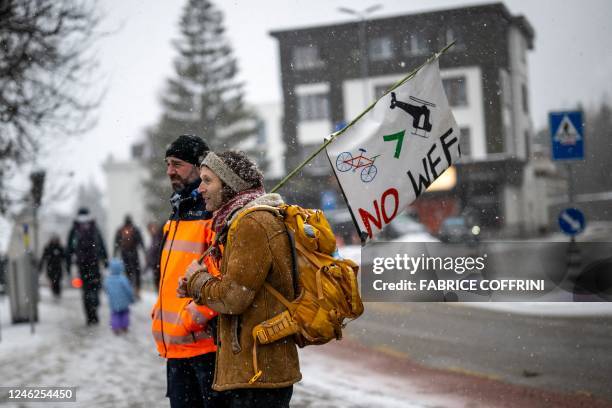 An activist stands next to a police officer during a protest of the Young Socialists Switzerland against the World Economic Forum , calling for a...