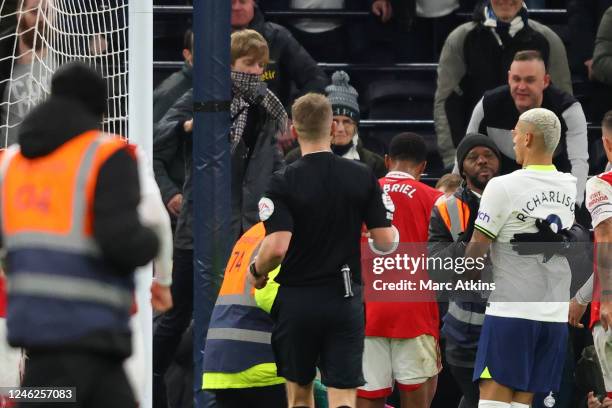 Fan, centre left reacts toward Aaron Ramsdale of Arsenal as Richarlison of Tottenham Hotspur looks on after the Premier League match between...